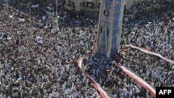 Ðám đông biểu tình chống Tổng thống Bashar al-Assad giương ra một lá cờ Syria lớn tại trung tâm thành phố Hama, Syria, ngày 29 tháng 7, 2011