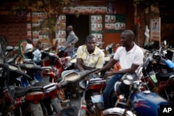 FILE - Supporters of an opposition coalition sit outside a local alliance office in Bamako, Mali.