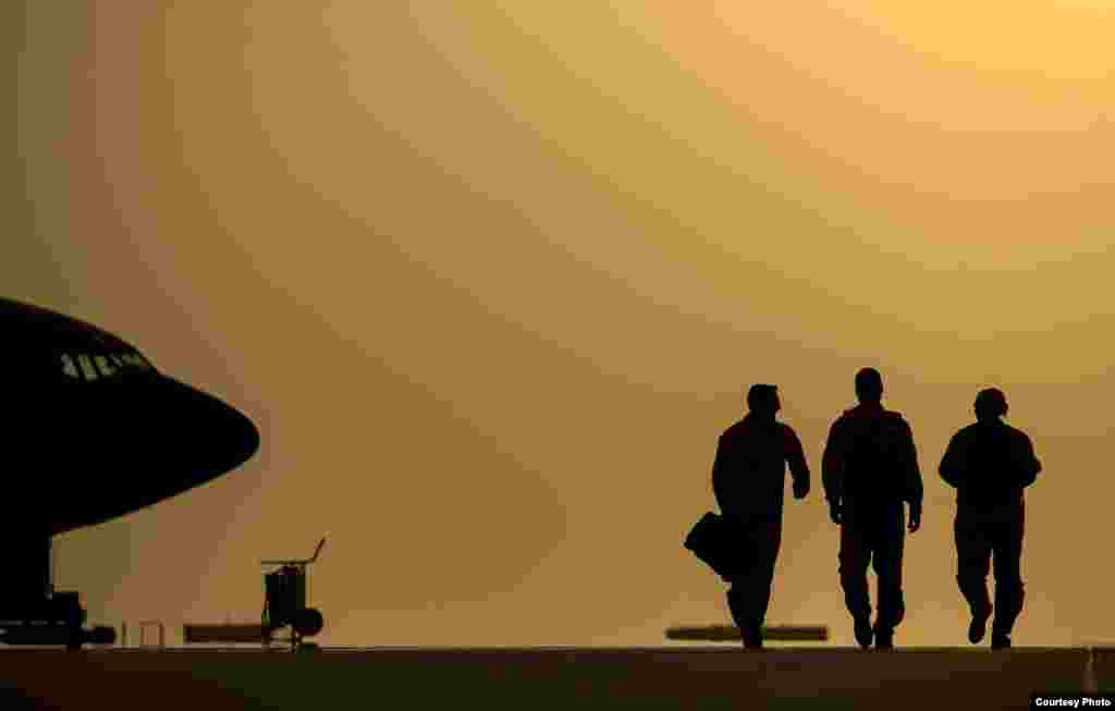 U.S. Air Force Captains Andrea Delosreyes, Trent Parker and Airman 1st Class Kevin Haggith, 340th Expeditionary Air Refueling Squadron, KC-135 Stratotanker aircrew, head to their aircraft for in-air refueling for F-16 Fighting Falcons completing missions over Iraq, Aug. 11, 2014. (U.S. Department of Defense)