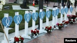 FILE - The names of 11 victims are written on hearts as people gather for a candlelight vigil after a mass shooting during Chinese Lunar New Year celebrations in Monterey Park, California, Jan. 24, 2023. 