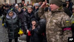The loved ones of Ukrainian military serviceman Oleg Kunynets cry during his funeral in Lviv, Ukraine, Feb 7, 2023. Germany, Denmark and the Netherlands said Tuesday they plan to send at least 100 older, refurbished Leopard 1 tanks to Ukraine to boost its defense against Russia.