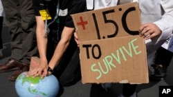 FILE - Demonstrators pretend to resuscitate the Earth while advocating for the 1.5 degree warming goal to survive at the COP27 U.N. Climate Summit, Nov. 16, 2022, in Sharm el-Sheikh, Egypt.