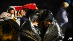 FILE - Two women from Cuba try to keep warm after crossing the border from Mexico and surrendering to authorities to apply for asylum, Nov. 3, 2022, near Yuma, Arizona.
