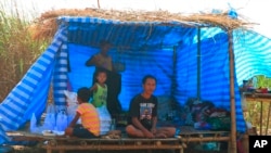 Displaced people from Myanmar live under a makeshift tent along the Thai side of the Moei River in Mae Sot, Thailand, on Feb. 7, 2022.