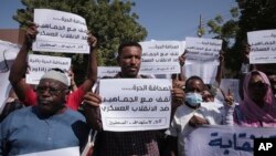 FILE - Sudanese journalists protest in Khartoum, Sudan, Nov.16, 2021. Many of the placards read: "We stand with the masses against the military coup." 