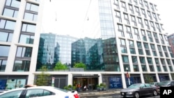 A police car is parked in front of a a luxury apartment building in Washington, April 7, 2022. Federal prosecutors on Wednesday charged two men they say were posing as federal agents, giving free apartments and other gifts to US Secret Service agents.