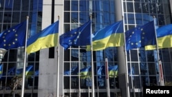 ARCHIVO - Las banderas de la Unión Europea y Ucrania ondean frente al edificio del Parlamento Europeo, en Bruselas, Bélgica, el 28 de febrero de 2022.