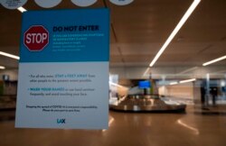 A sign about stopping the spread of COVID-19 is posted at Los Angeles International Airport (LAX) during the outbreak of the novel coronavirus, which causes COVID-19, April 16, 2020, in Los Angeles.