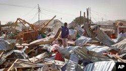 A shopkeeper surveys the wreckage of shops destroyed by a blast in a market in the capital Mogadishu, Somalia, Feb. 19, 2017. 
