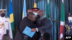 ARCHIVES - Le président Félix Tshisekedi (à dr.) et l'ex-président kenyan, Uhuru Kenyatta après la signature de l'adhésion de la RDC à la Communauté des États de l'Afrique de l'Est (CEA), à Nairobi, au Kenya, le 8 avril 2022.