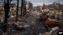 A Ukrainian serviceman walks amid destroyed Russian tanks in Bucha, on the outskirts of Kyiv, Ukraine, April 6, 2022. 