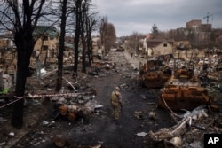 A Ukrainian serviceman walks amid destroyed Russian tanks in Bucha, on the outskirts of Kyiv, Ukraine, April 6, 2022.