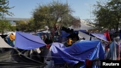 FILE - Migrants sent back to Mexico pass their time at an encampment yards away from the border in Reynosa, Mexico, April 1, 2022. 