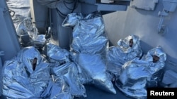 A group of migrants huddle, wrapped in emergency blankets, after being rescued from the water off the island of Evia, Greece, Nov.1, 2022. (Hellenic Coast Guard/Handout)