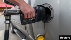 A customer gets gasoline at a gas station in Plains, Pennsylvania, U.S. Oct. 19, 2022.