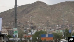 Afghan security forces inspect the site of a bomb explosion in Kabul, Afghanistan, May 18, 2020. A suicide bomber in a stolen military Humvee targeted a base of the country's intelligence service in Ghazni province.
