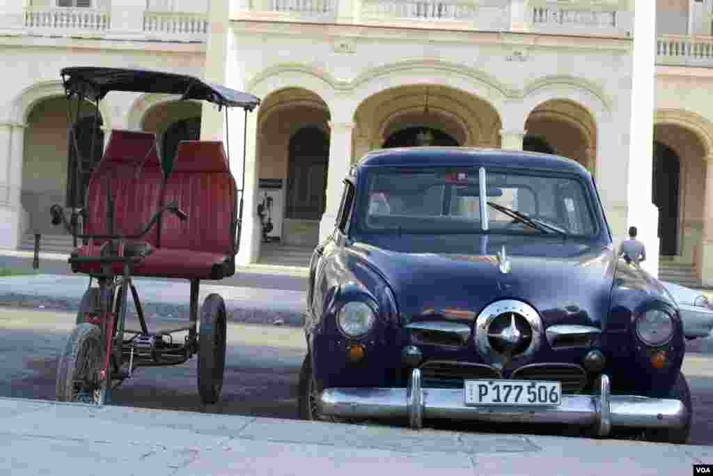 Old cars and rustic transportation methods are the norm around Cuba. These two were parked in front of the Museo de la Revolucion (Museum of the Revolution) in Havana, Aug. 13, 2015. (Celia Mendoza/VOA)