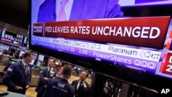 The rate decision of the U.S. Federal Reserve appears on a television screen, on the floor of the New York Stock Exchange, in New York City, Sept. 20, 2017.
