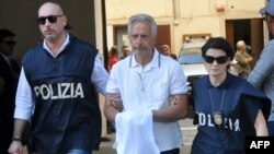 Italian police officers escort Francesco Inzerillo (C) after he was arrested in Palermo during an police/FBI operation called 'New Connection' on July 17, 2019. 
