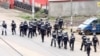 FILE - A still image taken from video shows riot police walk along a street in the English-speaking city of Buea, Cameroon Oct. 1, 2017.