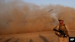 FILE - A U.S. Marine takes part during a training session for Afghan army commandos in Shorab military camp in Helmand province, Afghanistan, Aug. 27, 2017. 