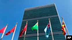 FILE - Flags fly outside the United Nations headquarters during the 74th session of the U.N. General Assembly, Sept. 28, 2019. 