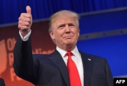 Real estate tycoon Donald Trump flashes the thumbs-up as he arrives on stage for the start of the prime time Republican presidential debate on Aug. 6, 2015 at the Quicken Loans Arena in Cleveland, Ohio.