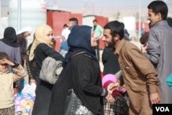 Some families are reunited when they arrive in refugee camps less than a day after running for their lives from IS militants, in Hammem Aleel, Iraq, Feb. 28, 2017. (H. Murdock/VOA)