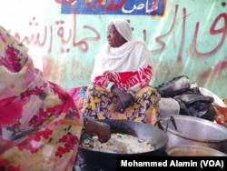 Tea seller Awadeya Mahmoud talks to a customer in Khartoum, Sudan.