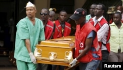 Mortuary workers and Kenya Red Cross volunteers carry the coffin containing the body of Mildred Yondo, a student killed during an attack by gunmen at Garissa University, from the Chiromo Mortuary in the capital Nairobi, April 8, 2015.