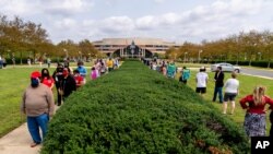 Una fila del largo de dos canchas de fútbol se extiende frente al centro de Gobierno de Fairfax, Virginia, durante una jornada de votación anticipada, el 18 de septiembre de 2020.