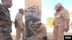 Pejuang Anti-Gaddafi merobohkan gerbang yang semula dibuat untuk pembatas wilayah kota Sirte dengan kota terdekatnya yang berjarak hampir 50 kilometer ke arah Timur (5/10).