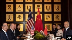 FILE - Chinese Vice Premier Liu He, right, sits with U.S. Trade Representative Robert Lighthizer, second from left, and Treasury Secretary Steven Mnuchin, left, before the start of talks at the Xijiao Conference Center in Shanghai, July 31, 2019.