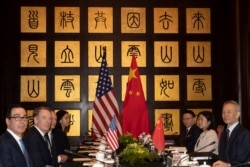 FILE - Chinese Vice Premier Liu He, right, sits with U.S. Trade Representative Robert Lighthizer, second from left, and Treasury Secretary Steven Mnuchin, left, before the start of talks at the Xijiao Conference Center in Shanghai, July 31, 2019.