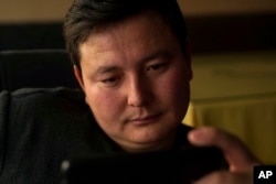 In this Dec. 9, 2018 photo, Kairat Samarkan, a former detainee in a Chinese internment camp, watches a state television report about what Beijing calls "vocational training centers" in a restaurant in Almaty in Kazakhstan.