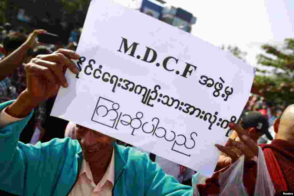 A man holds a sign as he waits for political prisoners to be released from Insein prison in Rangoon, Burma, Dec. 31, 2013.&nbsp;