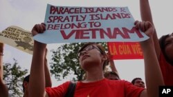 Protesters hold up Vietnamese flags and anti-China banners in front of the Chinese embassy during a protest against the alleged invasion of Vietnamese territory by Chinese ships in disputed waters in Hanoi, June 12, 2011