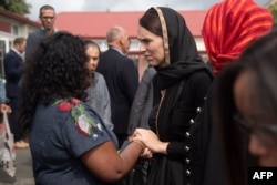 New Zealand Prime Minister Jacinda Ardern speaks with a woman during a visit to the Canterbury Refugee Center in Christchurch, March 16, 2019.
