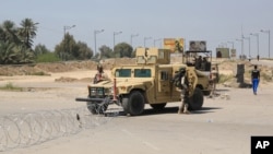 Iraqi soldiers stand guard at the site near a suicide attack that targeted a checkpoint manned by Iraqi troops, in Baghdad, Iraq, April 4, 2016.