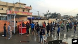 Warga berkumpul di lokasi ledakan di Sadr City, Baghdad, Irak hari Minggu (28/2) yang menewaskan sedikitnya 24 orang.