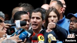 Venezuelan opposition leader and self-proclaimed interim president Juan Guaido, accompanied by his wife Fabiana Rosales, speaks to the media after a church service in Caracas, Venezuela, Jan. 27, 2019.