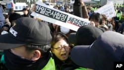 A South Korean protester scuffles with police officers during a rally to oppose the General Security of Military Information Agreement (GSOMIA) between South Korea and Japan, in front of the Defense Ministry in Seoul, South Korea, Nov. 23, 2016.