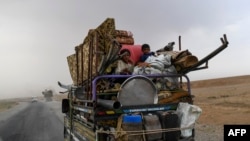 Displaced Syrians from Deir el-Zour head to refugee camps on the outskirts of Raqa on Sept. 24, 2017, as Syrian fighters backed by U.S. special forces battle to clear the last remaining Islamic State group jihadists holed up in their crumbling stronghold.