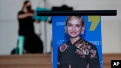 A musician plays a violin behind a photograph of cinematographer Halyna Hutchins during a vigil in her honor in Albuquerque, N.M., Saturday, Oct. 23, 2021. Hutchins was fatally shot on Thursday, Oct. 21, on a movie set in New Mexico.