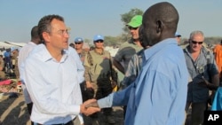 The U.N.'s top humanitarian official in South Sudan, Toby Lanzer (L), who was expelled from the country, visits displaced persons at a U.N. compound in 2013.