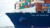 Miembros de la tripulación del CMA CGM Argentina, el barco carguero más grande en hacer escala en el Puerto de Miami, miran desde la proa el 6 de abril de 2021.