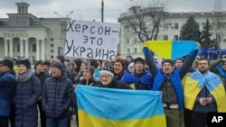  People hold Ukrainian flags and a banner that reads "Kherson is Ukraine" during a rally against Russian occupation in Svobody (Freedom) Square in Kherson, March 5, 2022. (Associated Press)