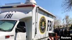 Law enforcement personnel including FBI agents are seen March 13, 2018, near a home that was hit with a parcel bomb in Austin, Texas. 