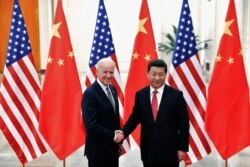 Presiden China Xi Jinping berjabat tangan dengan Joe Biden, yang saat itu masih menjabat sebagai Wapres AS(kiri) di dalam Aula Besar Rakyat di Beijing 4 Desember 2013. REUTERS/Lintao Zhang/Pool/File Photo