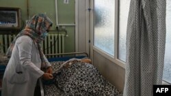 কাবুলের ওয়াজির আকবর খান হাসপাতালে একজন নারী নার্স একজন রোগির শুশ্রুষা করছেন। ১ সেপ্টেম্বর, ২০২১। 